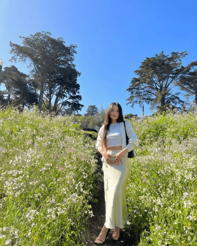 Outfit cực tôn dáng cho những buổi check-in tại vườn hoa Sa Pa tháng 4 là chân váy dáng dài cạp cao, áo croptop trắng và 1 chiếc áo khoác len mỏng bên ngoài