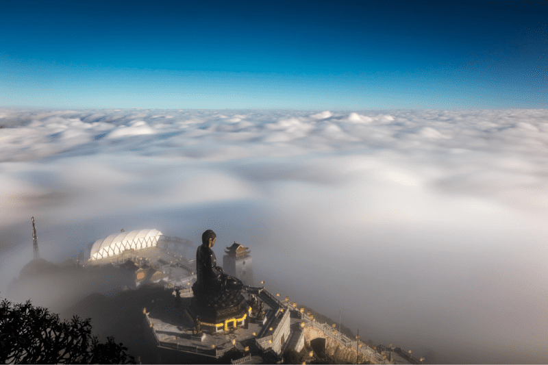 Góc nhìn Đại tượng Phật từ trên cao giữa mây mù phủ khắp đồi núi
