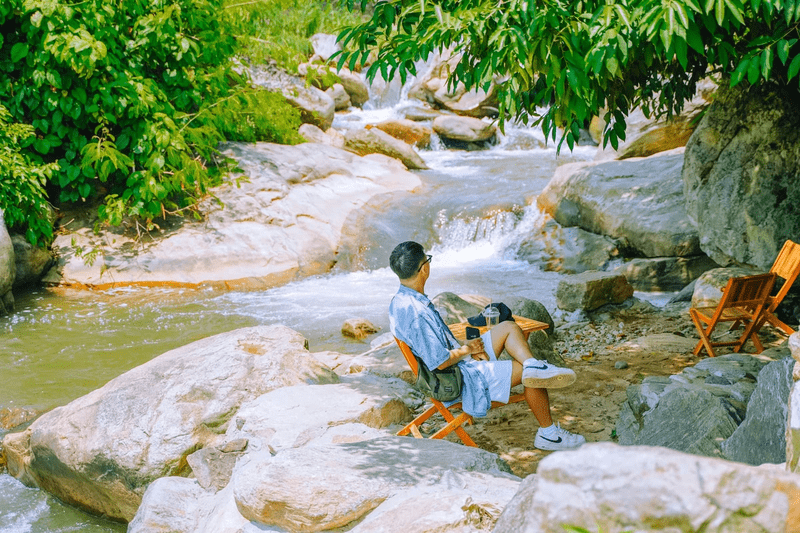 Du khách nghỉ ngơi, lắng nghe dòng chảy êm đền của suối Nậm Cang