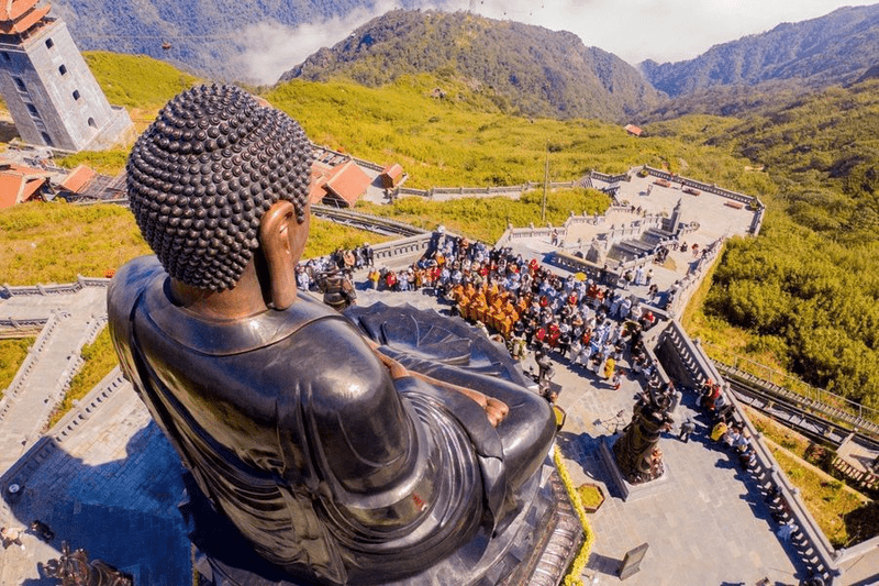 Du khách chiêm bái trước Đại tượng Phật A Di Đà tại quần thể các công trình tâm linh khu vực đỉnh Fansipan