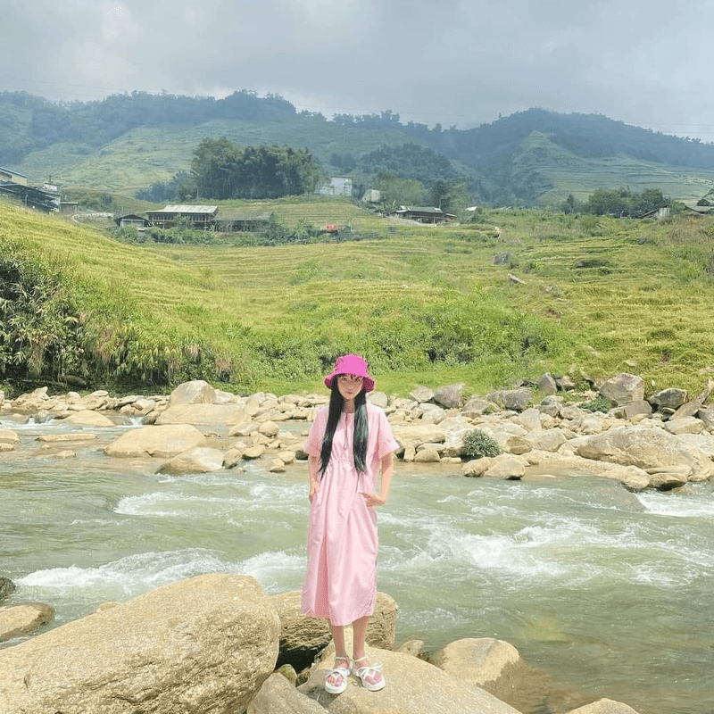 Mix đồ đi Sa Pa mùa hè đồ đơn giản với váy liền dài quá gối, xăng đan đế bệt và mũ vải đều màu hồng
