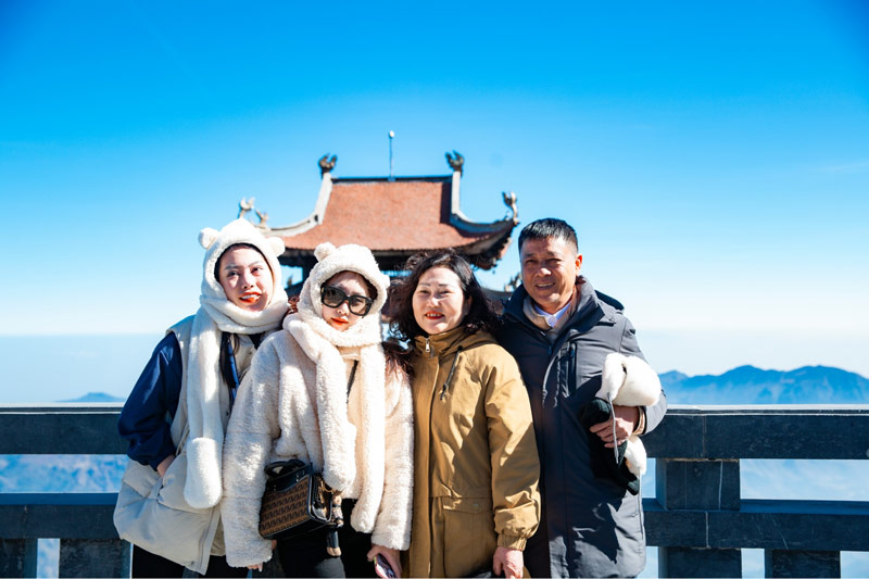 Nhóm gia đình vui vẻ chụp ảnh tại quần thể kiến trúc tâm linh trên đỉnh núi