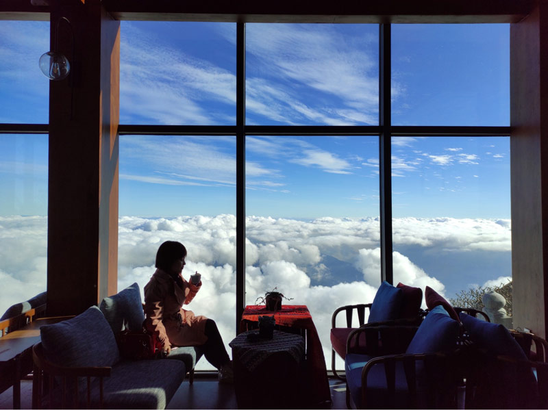Du khách nhâm nhi tách cà phê thơm ngon, dõi mắt về biển mây bao quanh Du Soleil