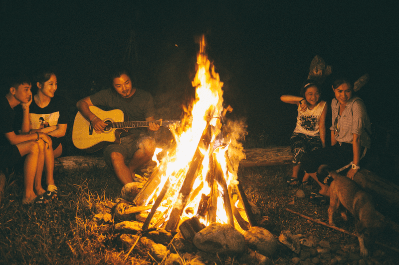 Nhóm bạn bè đàn hát vui vẻ bên ánh lửa trại bập bùng 
